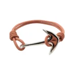 Brazalete náutico color salmón con ancla de acero inoxidable pulido, sobre fondo blanco."