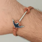 "Joyas náuticas: Brazalete unisex con diseño de ancla en acero y cordón doble anudado color piel."