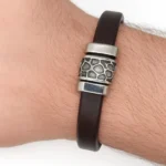"Brazalete de Piel Nórdico con Detalle de Acero en color negro y pieza central grabada."