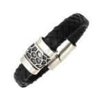 "Primer plano de pulsera de piel trenzada marrón con cierre de tubo magnético de acero plateado con textura de labrado."