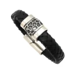 "Primer plano de pulsera de piel trenzada marrón con cierre de tubo magnético de acero plateado con textura de labrado."