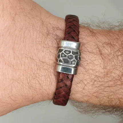 "Brazalete de Piel Trenzada con Acero Labrado y cierre magnético, color marrón oscuro."