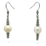 Pendiente con perla grande y abalorios de acero que forman un patrón simétrico.