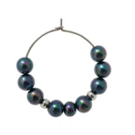 Arete colgante con perla con brillo suave y montura de metal plateado.