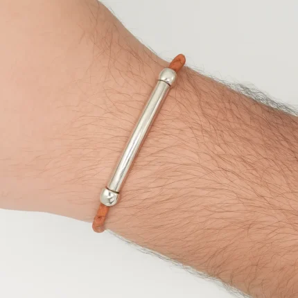 Pulsera artesanal de cuero trenzado marrón con barra central de acero inoxidable pulido, diseño moderno y elegante hecho a mano.