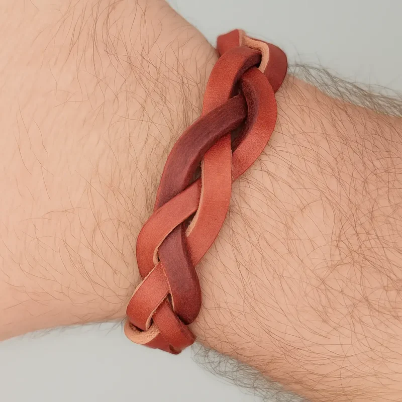 Pulsera artesanal trenzada de cuero marrón con cierre metálico magnético.
