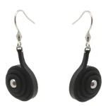 Pendiente artesanal con cuero en caracol en capas y detalle metálico central, colgado de un gancho plateado.